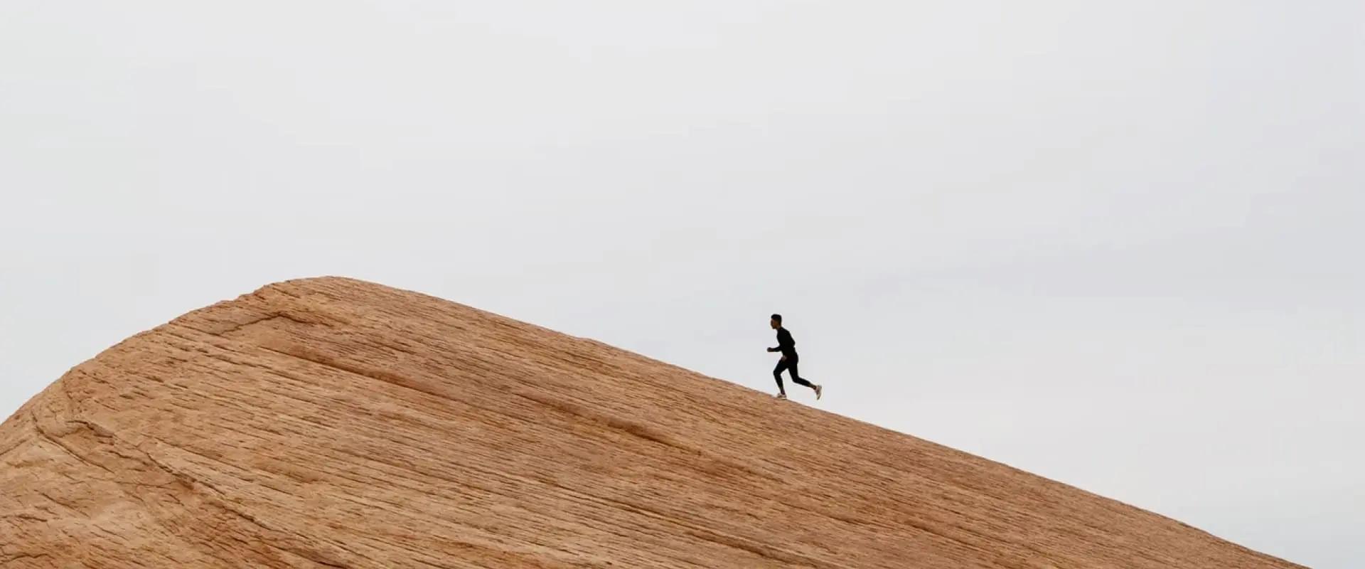 Distant plan of a running man on a rock